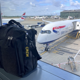 Mini Crew Luggage Tag in Black and Yellow on crew luggage tag with British Airways A350 Airplane In the Background in London Heathrow Airport
