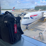 Mini Crew Luggage Tag in Red and White on crew luggage tag with British Airways A350 Airplane In the Background in London Heathrow Airport